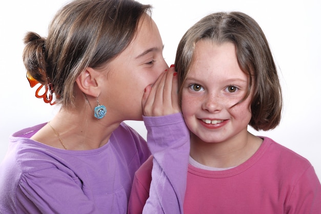 Complicity between sisters on white background