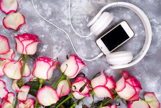 Photo composed frame of the roses and mobile phone with headphones