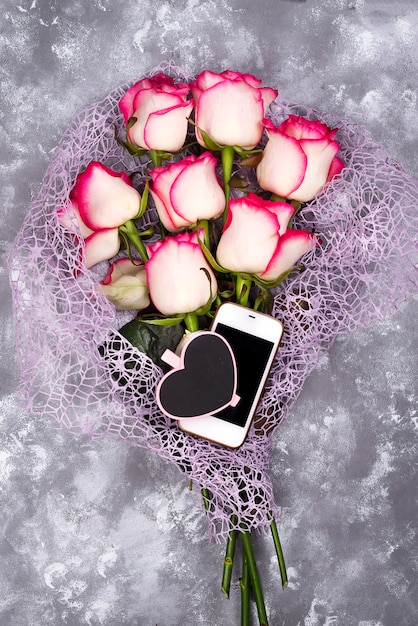 Photo composed of the roses and mobile phone adn chalkboard heart