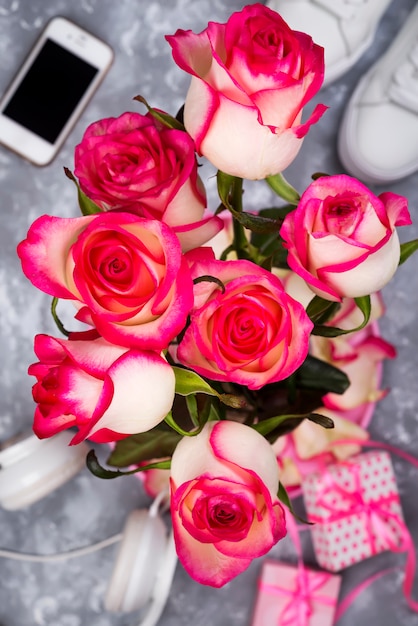 Photo composed of the roses and mobile phone on the back of a blurry background