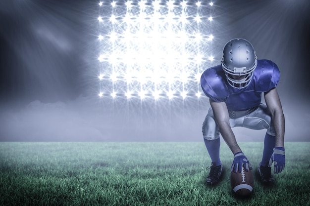 Composietbeeld van American football-speler die bal vasthoudt terwijl hij hurkt met 3d