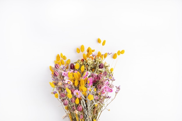 Composing bouquet of dry flowers and herbs, trendy interior decoration, artisan florist shop idea. Top view, flat lay