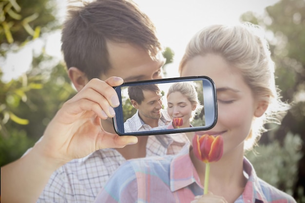 Photo composite of couple taking selfie on smartphone