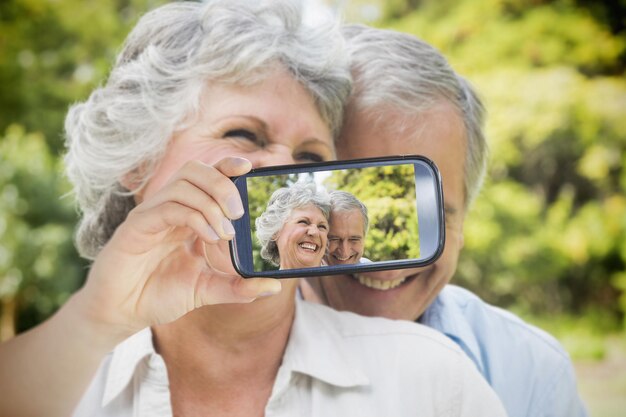 Photo composite of couple taking selfie on smartphone