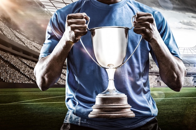 Composite image 3D of mid section of sportsman holding trophy