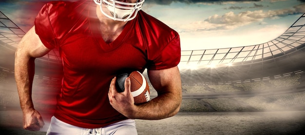 Composite image of american football player holding ball