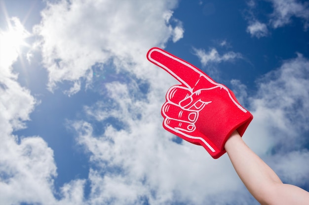 Composite image of american football player holding supporter foam hand