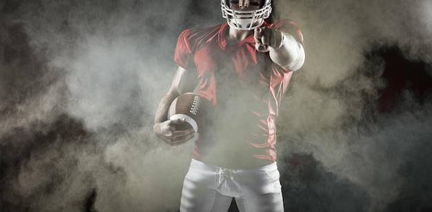 Composite image of american football player pointing at camera