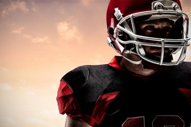 Composite image of american football player standing in rugby helmet