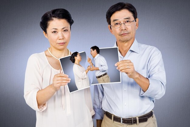 Composite image of asian couple holding a photo