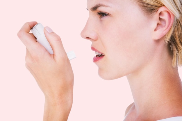 Composite image of asthmatic pretty blonde woman using inhaler