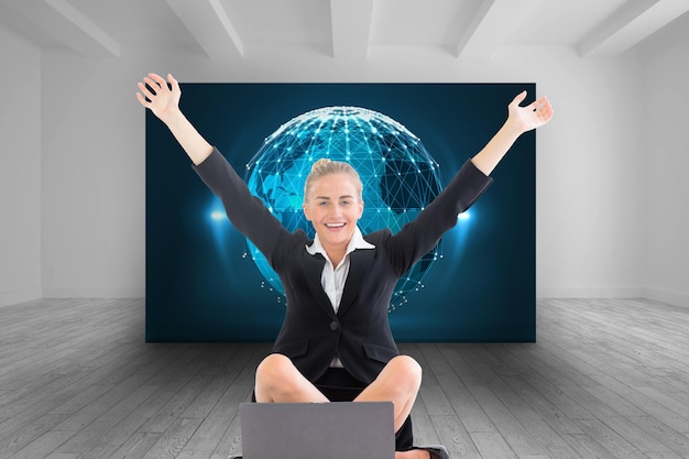 Foto immagine composita della donna di affari bionda attraente che si siede davanti al computer portatile con le braccia in su