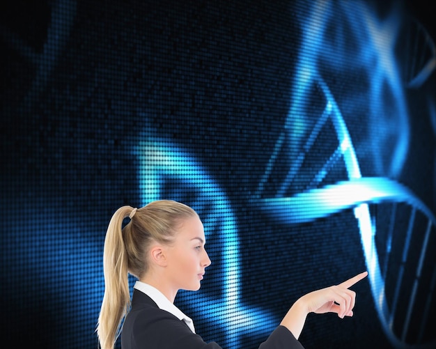 Composite image of blonde businesswoman pointing somewhere on black background with glowing blue dna spiral