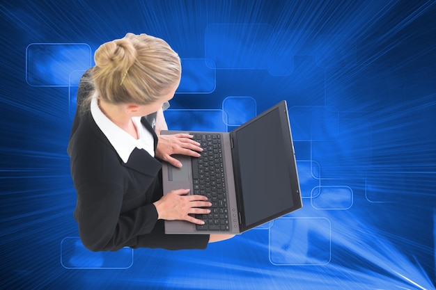 Foto immagine composita della bionda imprenditrice utilizzando il computer portatile