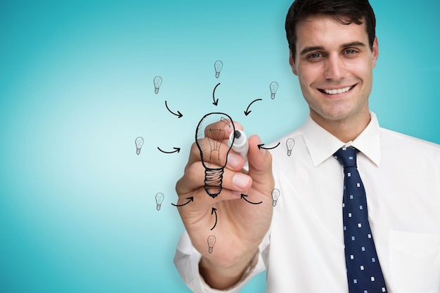 Composite image of businessman drawing light bulb against blue vignette