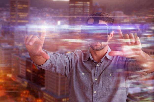 Composite image of businessman gesturing while using virtual reality simulator