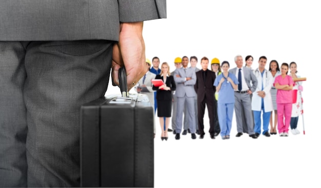 Composite image of businessman holding briefcase against group of workers