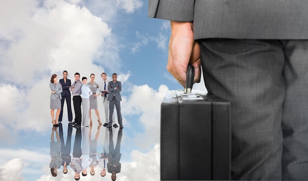 Composite image of businessman holding briefcase