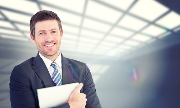 Composite image of businessman holding his laptop tightly