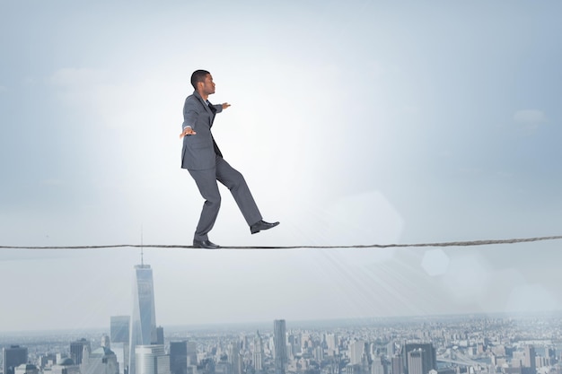 Composite image of businessman performing a balancing act