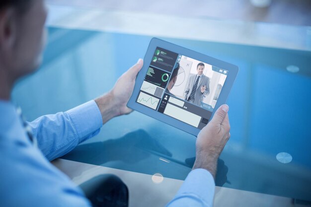 Composite image of businessman using his tablet