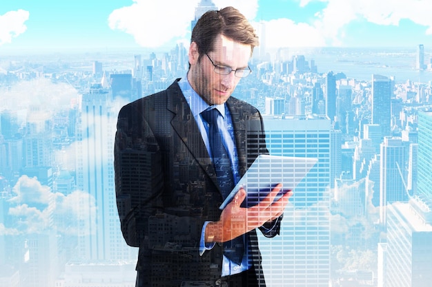 Composite image of businessman using a tablet computer