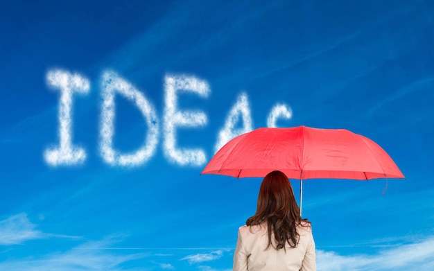 Composite image of businesswoman standing back to camera holding red umbrella