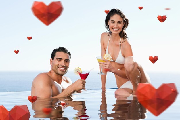 Составное изображение веселой пары с коктейлями в бассейне