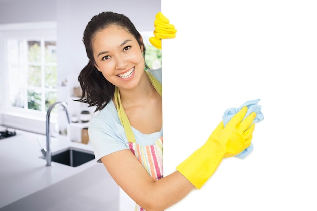 Составное изображение веселой женщины, чистящей белую поверхность