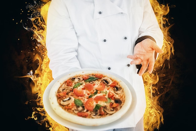 Composite image of chef displaying delicious pizza