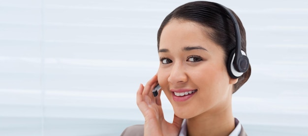 Composite image of close up of a smiling operator posing with a headset