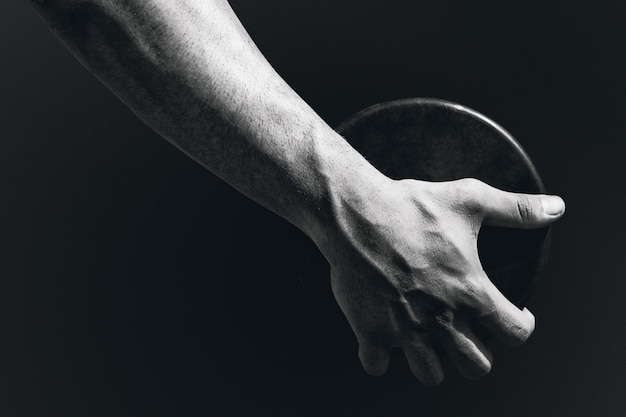 Composite image of close up of sportsman hand is holding a discus