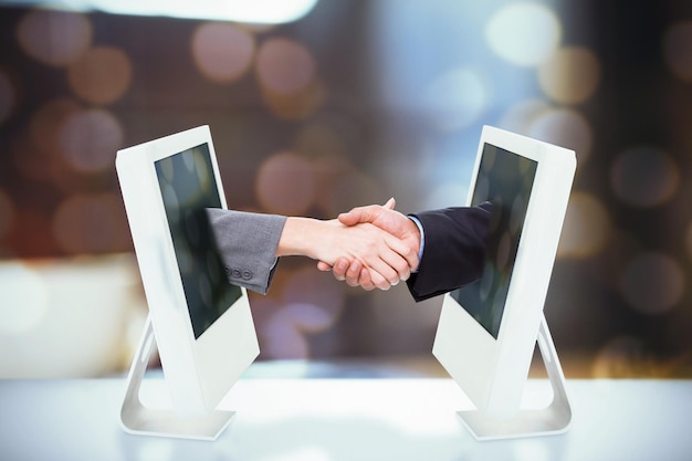 Composite image of close up of two businesspeople shaking their hands