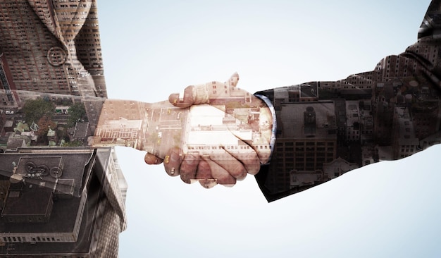 Photo composite image of close up of two businesspeople shaking their hands