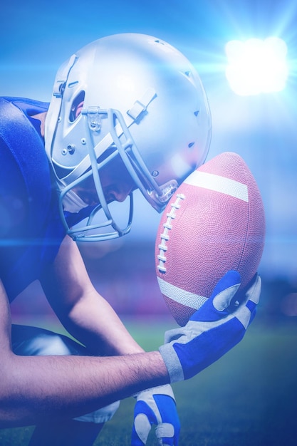 Immagine composita del primo piano del giocatore di football americano sconvolto con la palla