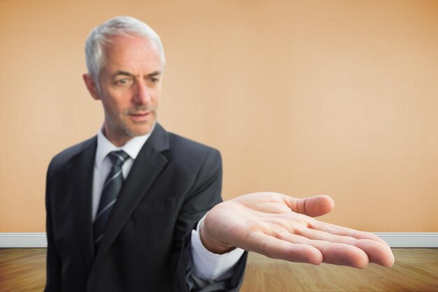 Composite image of concentrated businessman with palm up standing in bright 3d room