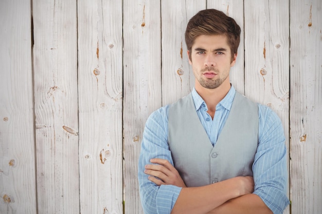 Составное изображение уверенного в себе бизнесмена, стоящего у деревянной стены