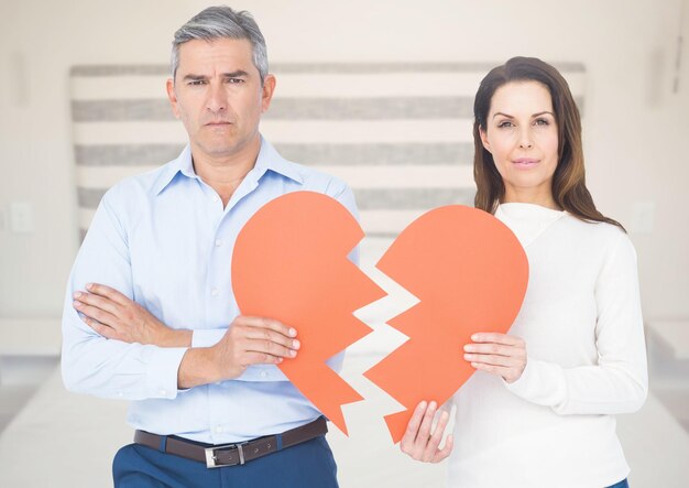 Composite image of couple holding broken heart