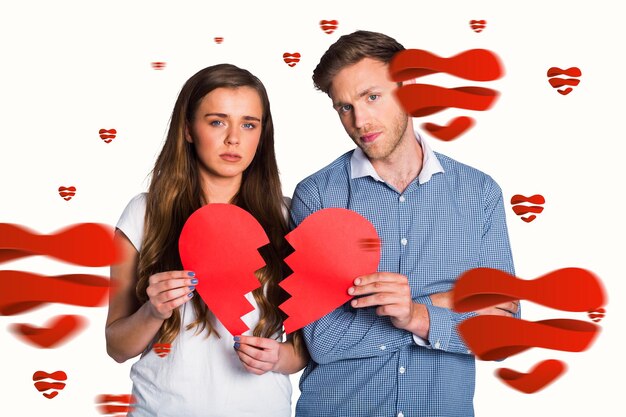 Composite image of couple holding broken heart