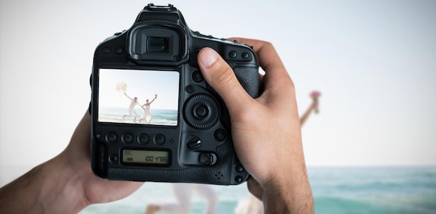 Composite image of cropped image of hands holding camera