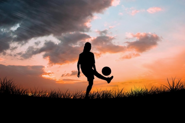 Composite image of cute football player kicking ball