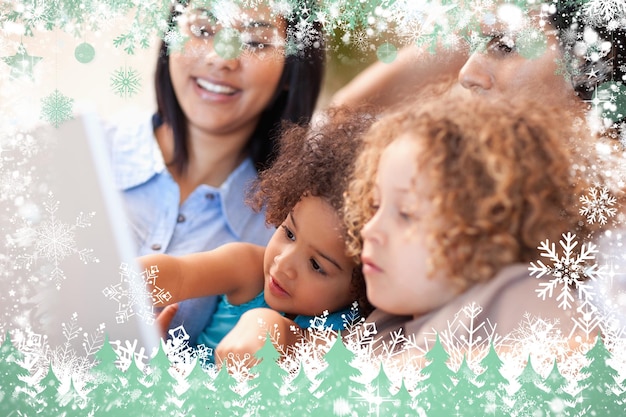 Composite image of family having a good time at the laptop together against snow