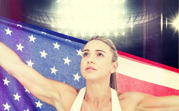 Composite image of female athlete holding american flag