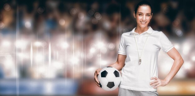 Composite image of female athlete holding a soccer ball