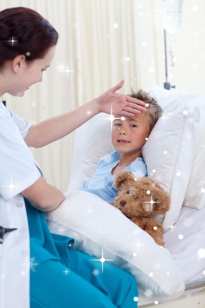 Composite image of female doctor checking child temperature with snow falling