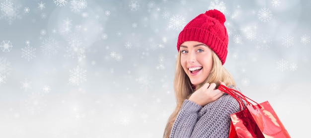 Composite image of festive blonde holding shopping bags