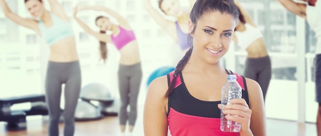 Составное изображение здоровой женщины, держащей бутылку с водой