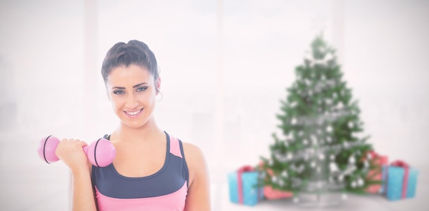 Composite image of fit woman lifting dumbbell weights with friend in background at gym