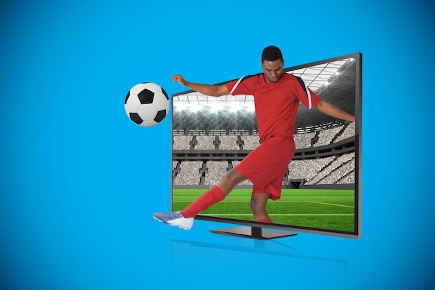 Составное изображение футболиста, пинающего мяч через телевизор против огромного футбольного стадиона с болельщиками в белом