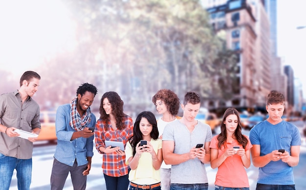 Composite image of four people standing beside each other and texting on their phones